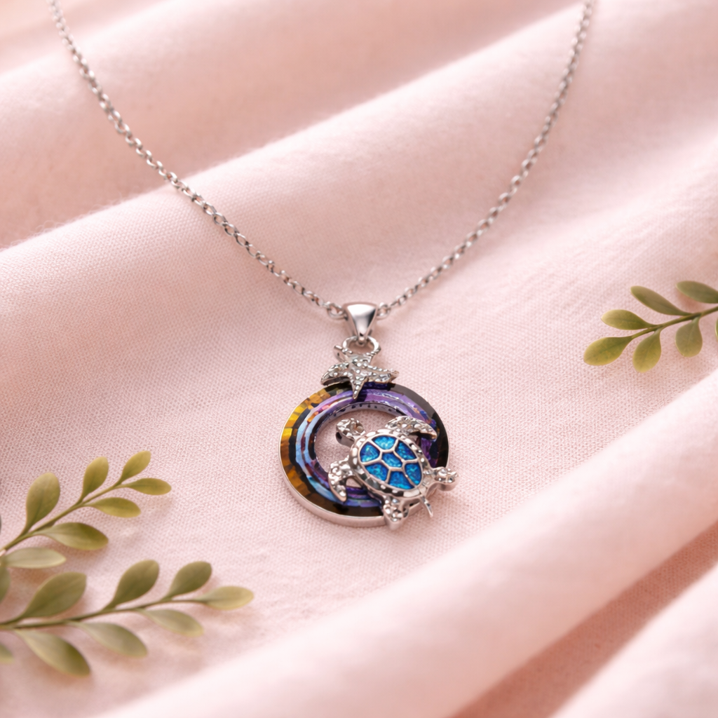 Silver tone sea turtle necklace with iridescent circle accent and starfish detail ocean-inspired jewelry