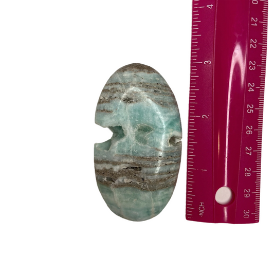 Blue Caribbean calcite palm stone, promotes emotional healing, communication, relaxation, and mental clarity; symbolizes comfort, balance, and tactile grounding.