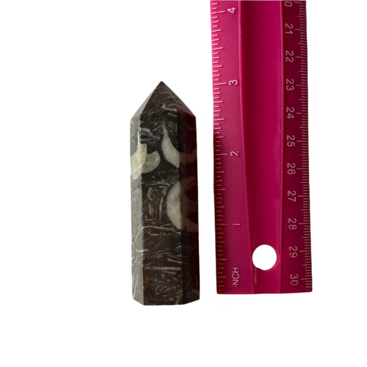Fossilized shell tower with natural textures and earthy tones, promotes grounding, focus, and connection to ancestral wisdom; symbolizes stability and energy amplification.