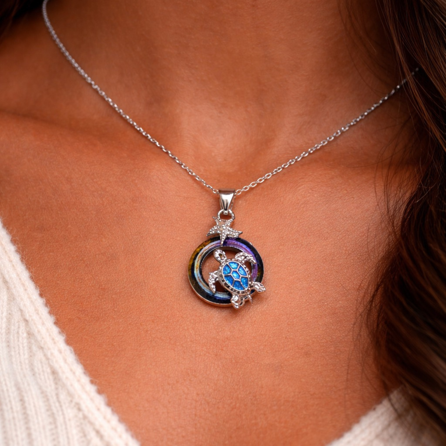Silver tone sea turtle necklace with iridescent circle accent and starfish detail ocean-inspired jewelry