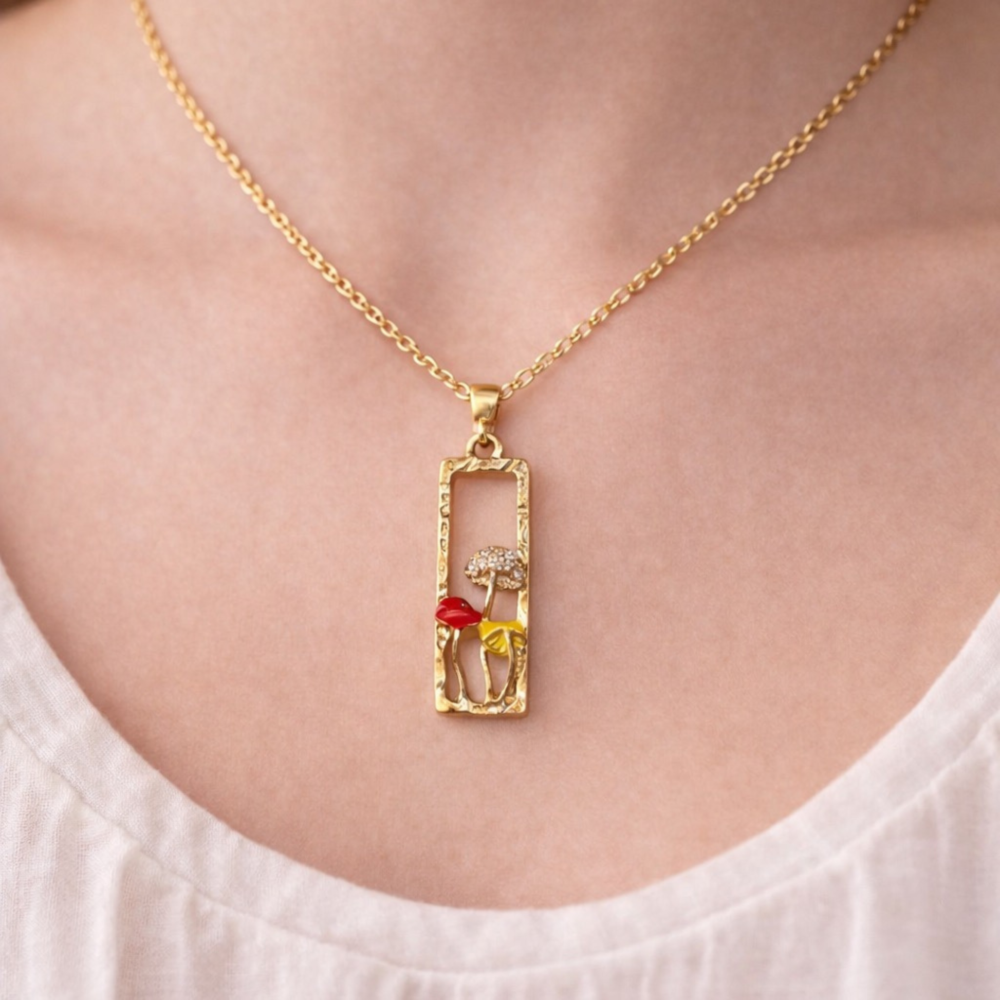 Gold tone necklace with rectangular pendant and colorful enamel mushrooms, whimsical forest-inspired jewelry