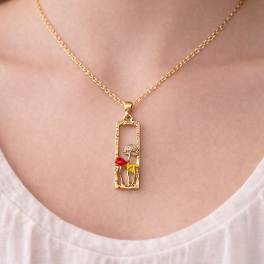 Gold tone necklace with rectangular pendant and colorful enamel mushrooms, whimsical forest-inspired jewelry