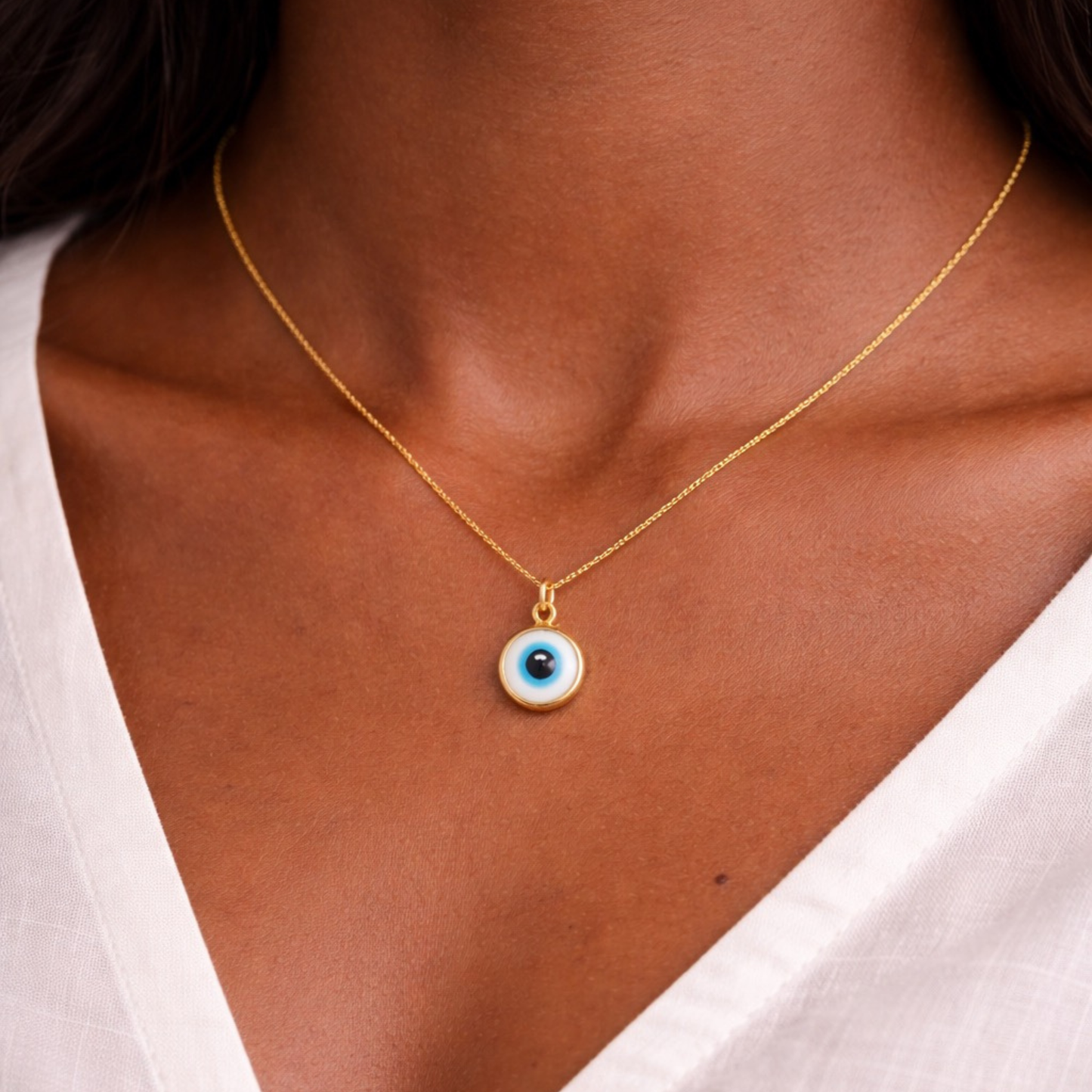 Woman wearing gold tone white evil eye necklace minimalist protective symbol jewelry