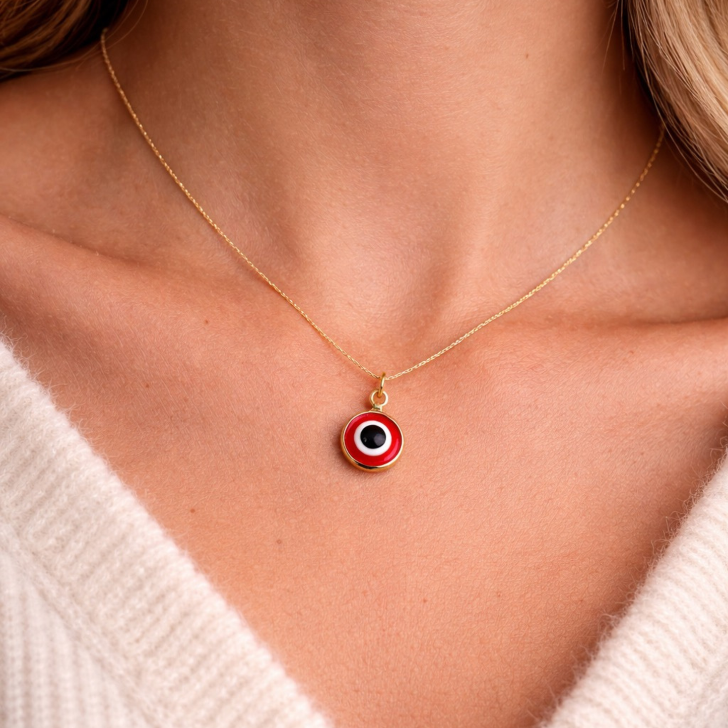 Woman wearing gold tone red evil eye necklace symbolic protection jewelry close up